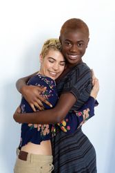 Affectionate female couple embracing happily in studio