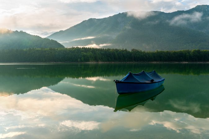 Boat on Lake Sylvenstein and the mountain reflection in the water
