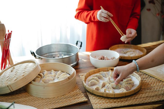 Cropped image of people making dumplings