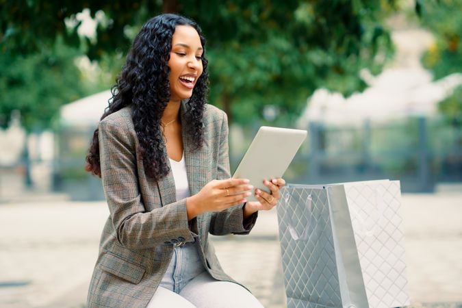 A Joyful Woman Happily Engaging with Her Tablet While Enjoying the Outdoors in Nature