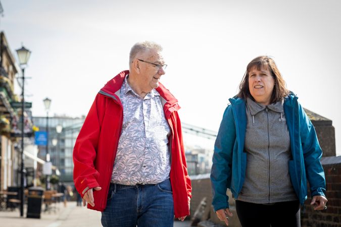 Older man and woman walking outside together