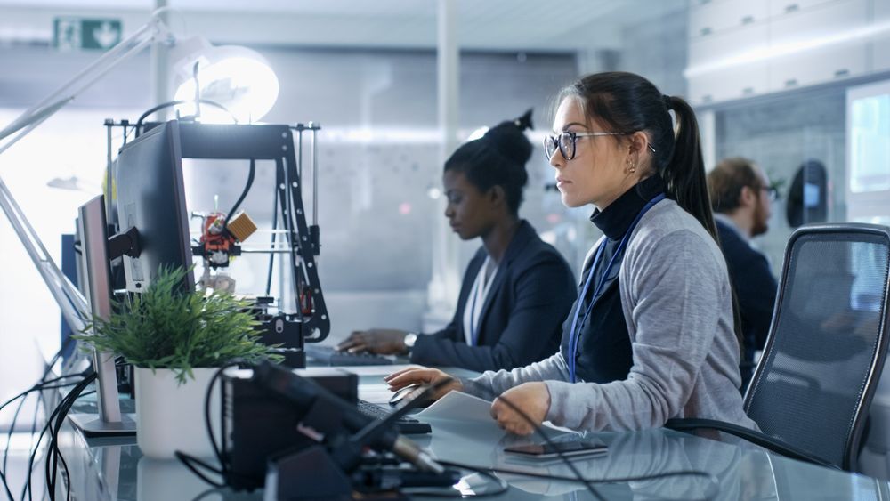 White Female Working on a Computer with Her Colleagus in a Modern High-Tech Laboratory.