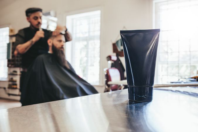 Focus on cosmetic cream on counter in barbershop