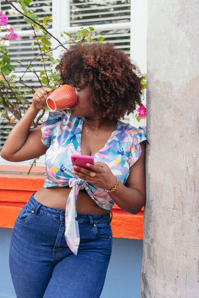 woman standing enjoying her coffee in the street