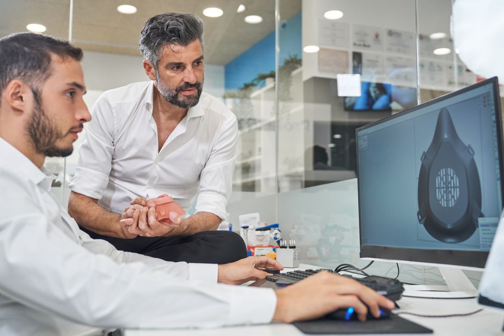 Concentrated coworkers designing model of respirator