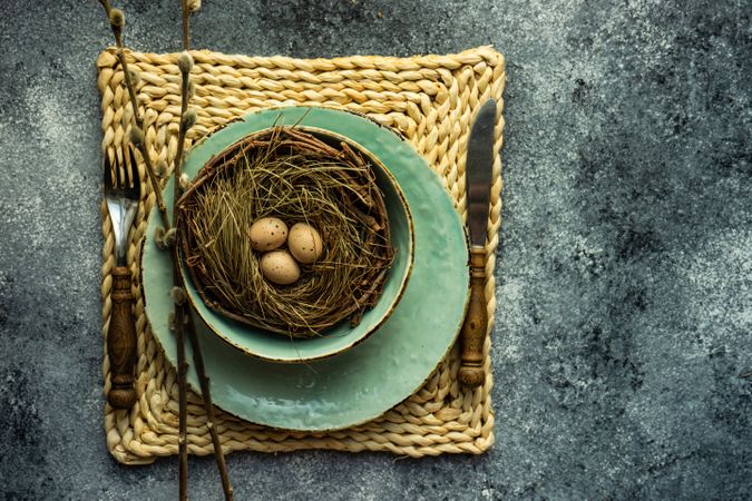 Top view of Easter holiday table setting with eggs in nest