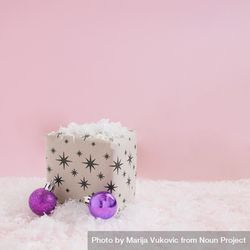 Starry giftwrap present with decorations sitting in snow 5q7qob
