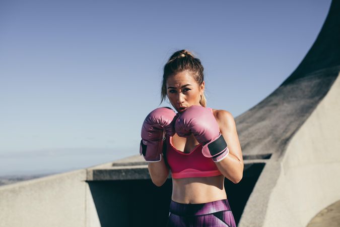Fit young female boxer ready for fight outdoors