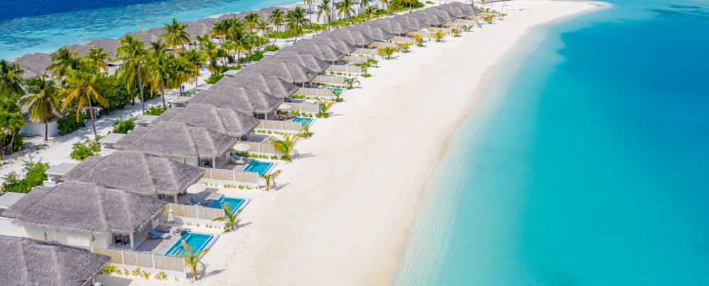 Wide shot of a row of holiday villas lining the beach