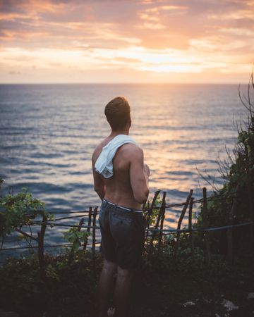 Traveler on high cliff viewing ocean