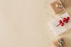 Paper brown Christmas presents on beige background with glitter