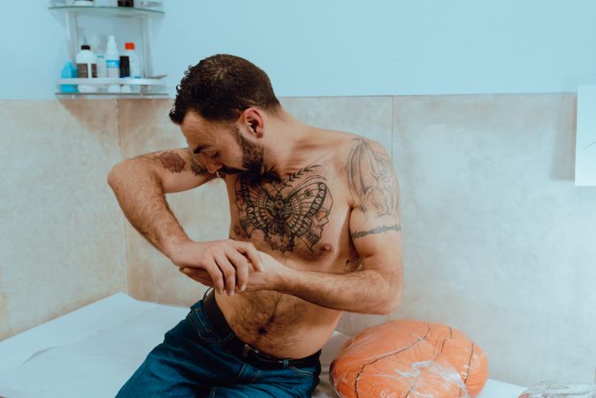 Young shirtless bearded guy with tattoos