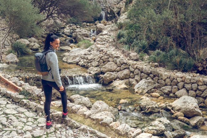 Smiling female traveler near fast river