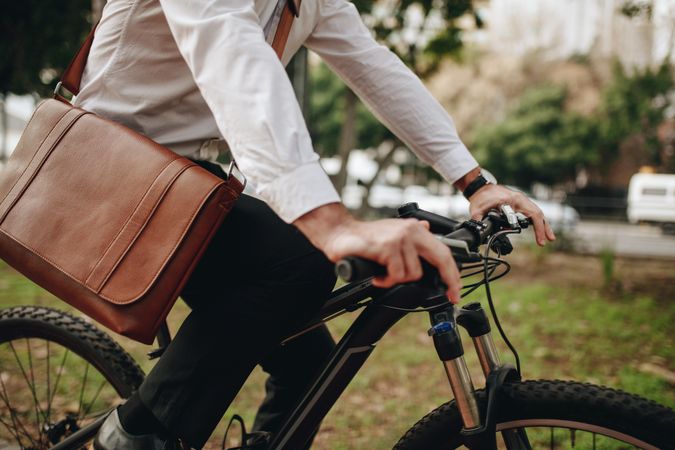 Man wearing an office bag riding a bike