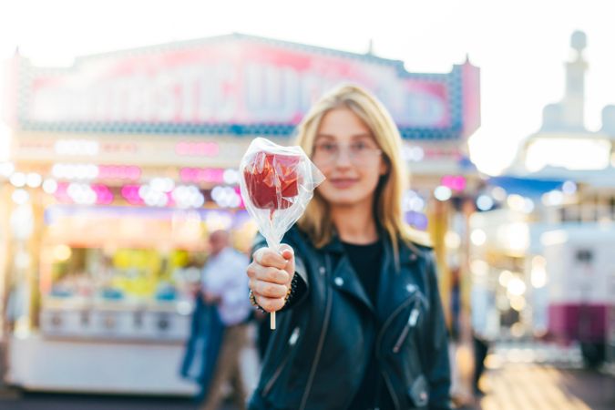 Stylish woman in chic clothes with a candied apple