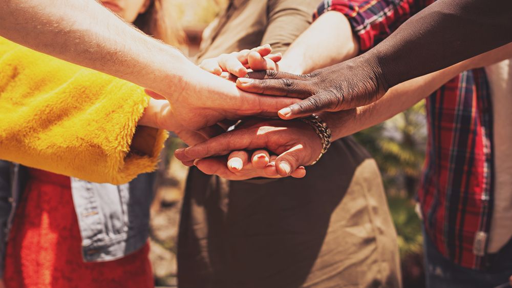 Diverse hands join in unity and cooperation, symbolizing diversity and inclusion