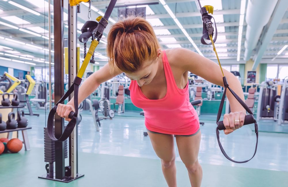 Woman doing push ups with stability ropes