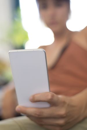 Woman blurred in background checking smartphone