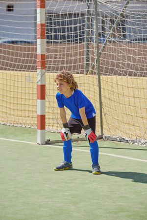Boy standing at football goal