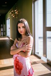 Stylish young woman in dress posing in room