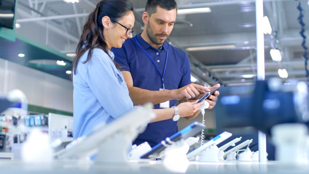 In the Electronics Store Consultant Gives Professional Advice to a Young Woman