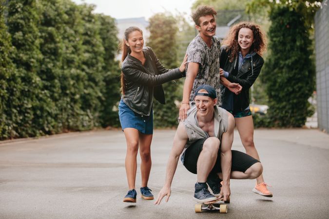 Four people enjoying outdoors with skateboard