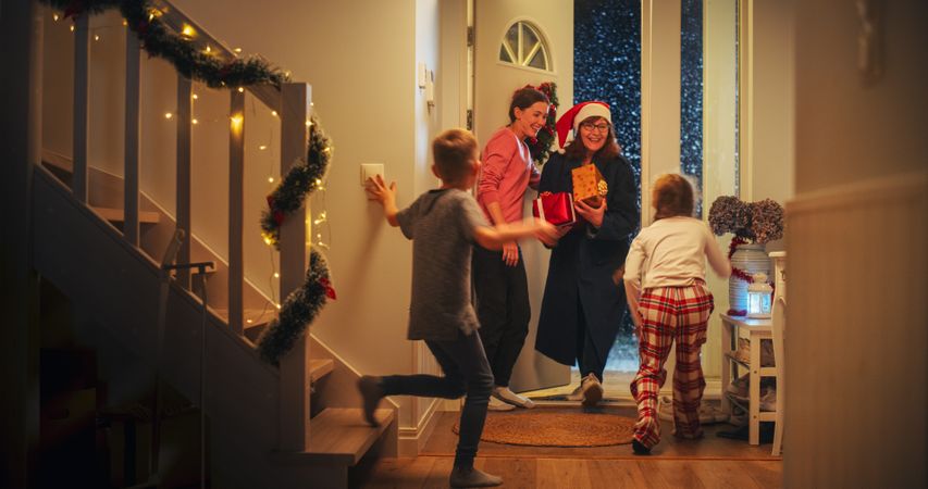 Grandmother Visiting Family for Christmas Holidays on a Snowy Winter Evening.
