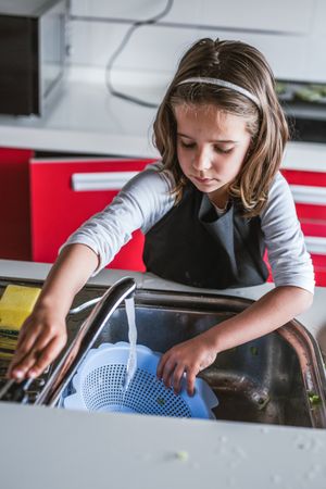 Girl washing dishes in kitchen