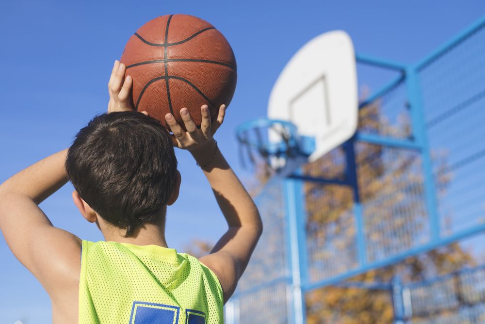 Teenager throwing a basketball into the hoop
