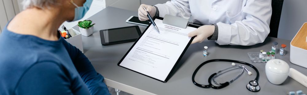 Doctor explaining to her patient consent form to coronavirus vaccine