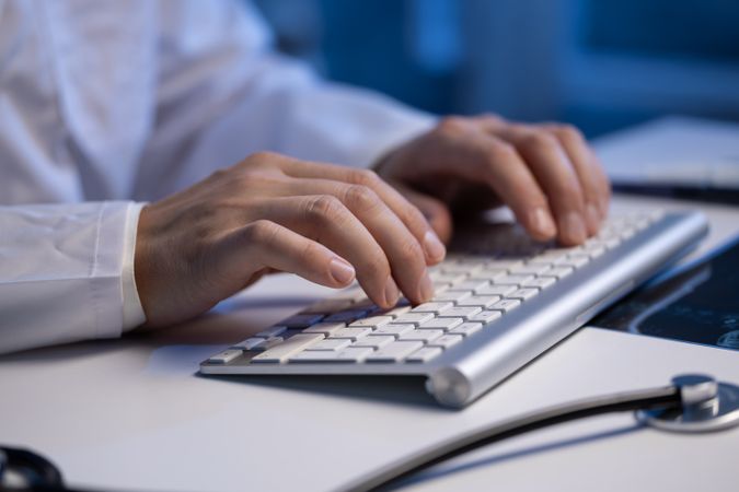 Doctor Typing on Keyboard in Office