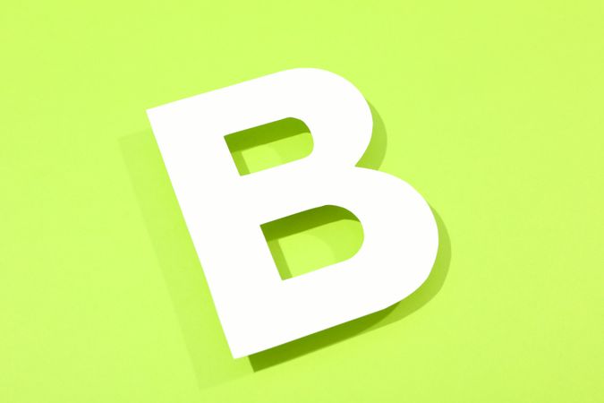 Paper letter B on color background, space for text