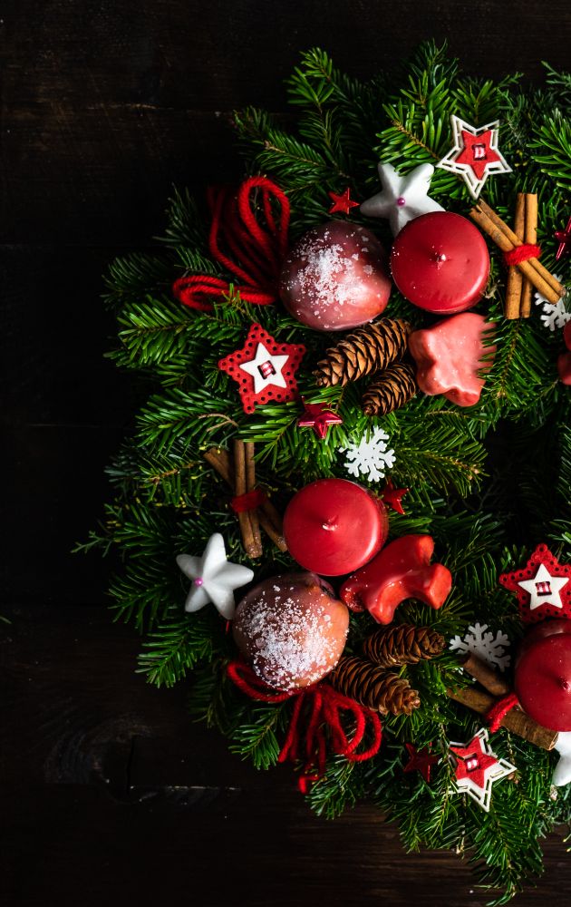 Christmas wreath with cinnamon sticks and red ornaments, vertical composition