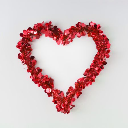 Red confetti shaped in heart outline on light background