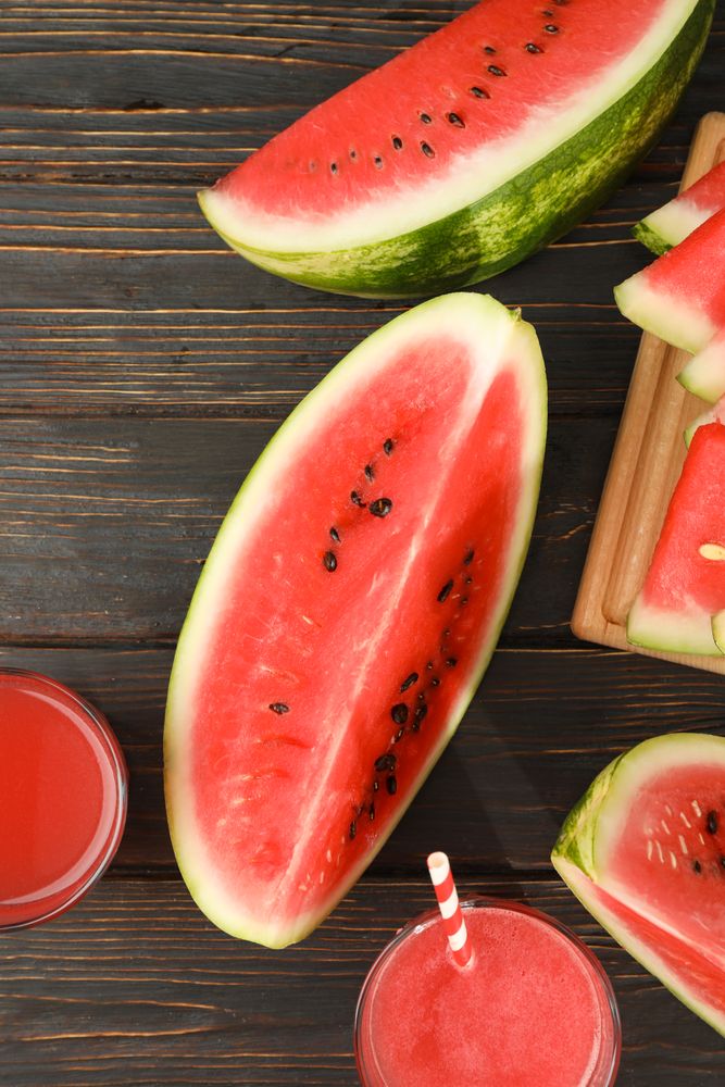 Composition with watermelon slices and juice on wooden background. Summer fruit