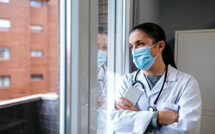 Female doctor looking out the hospital window