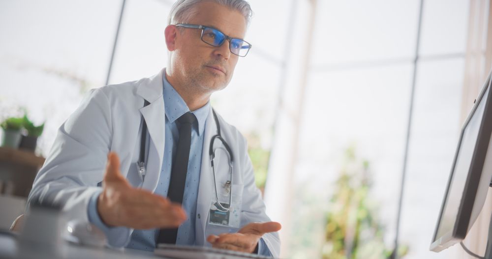 Professional Mature Doctor Explaining Medical Test Results to a Patient During a Health Check Visit