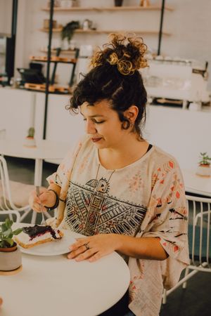 Delighted woman enjoying dessert in cafe