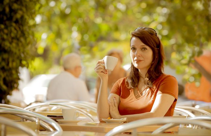 Adult female having tea in summer cafe