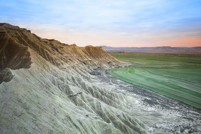 Stone desert hills near green field