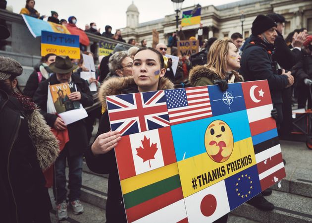 London, England, United Kingdom - March 5 2022: Woman at protest with sign with multiple flags