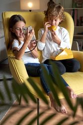 Content children using old telephone and new smartphone