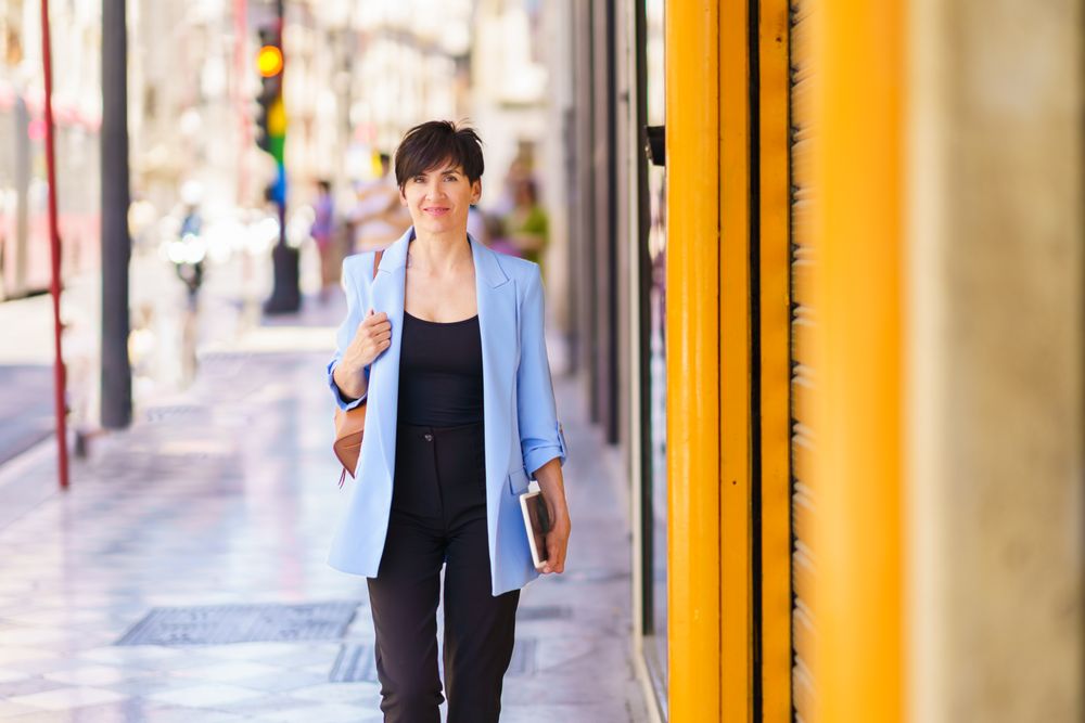 Woman in blue blazer walking down street