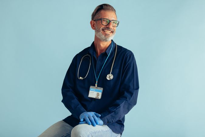 Portrait of a happy male doctor on blue background