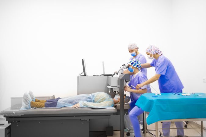 Medical professionals looking at patients eyes in surgery