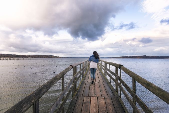 Woman walking on a bridge over calm lake in Germany