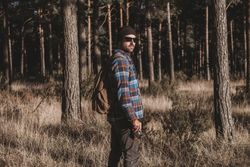 Confident tourist walking along autumn forest