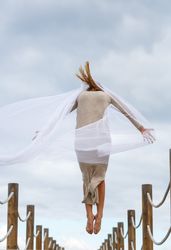 Woman with textile posing in air on footbridge
