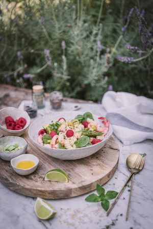 Tasty salad on wooden stand served on decorated table outside