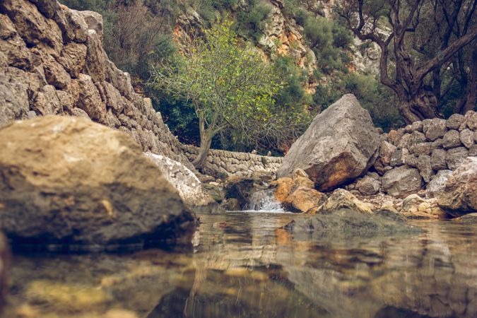 Scenic rocky ravine with small waterfall and river in daylight